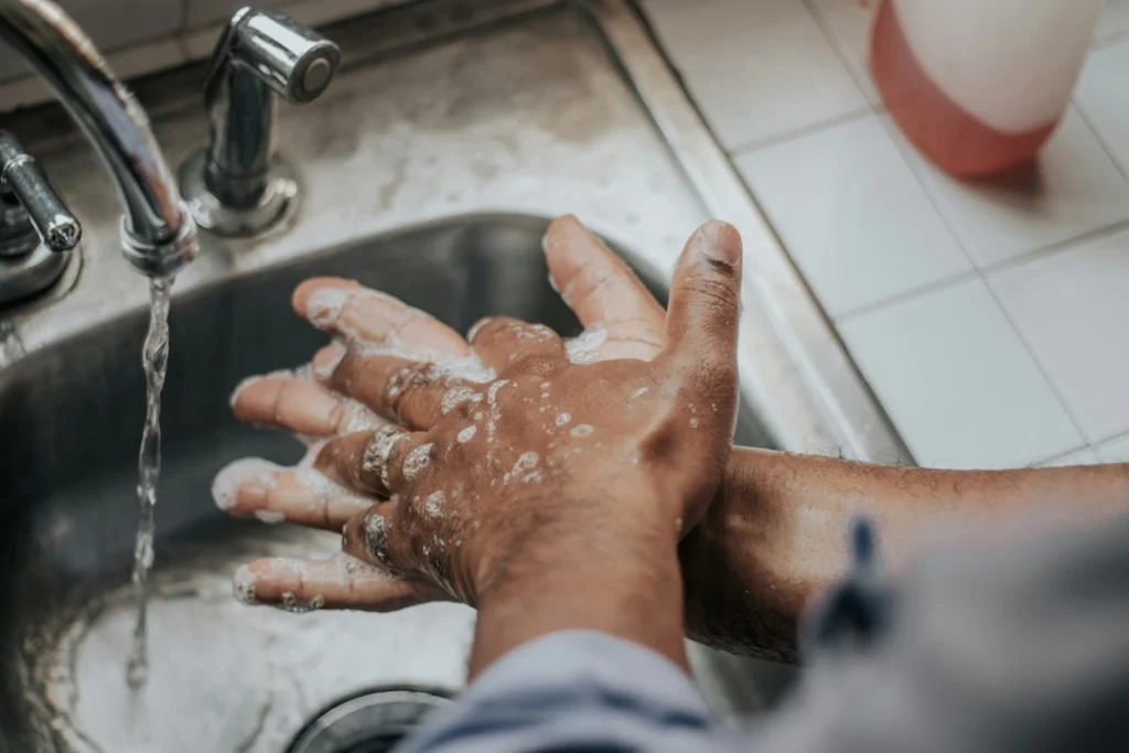 A photo of a man washing his hands at a sink